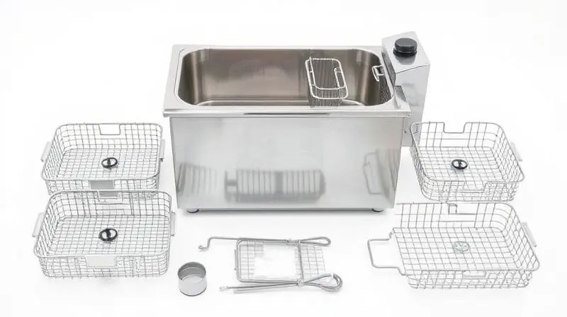 Fritadeira industrial de inox totalmente limpa e desmontada, com cestos e componentes organizados ao lado.