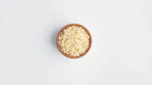 Fotografia profissional de uma tigela com grãos de arroz arbório, representando os melhores tipos de arroz para risoto disponíveis no mercado.