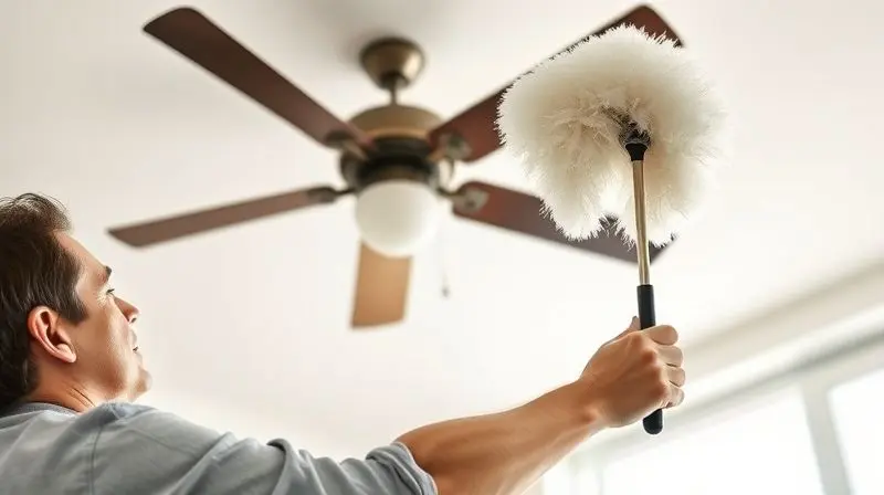 Pessoa utilizando um espanador com cabo extensível para alcançar e limpar um ventilador de teto, demonstrando a praticidade de cabos longos.